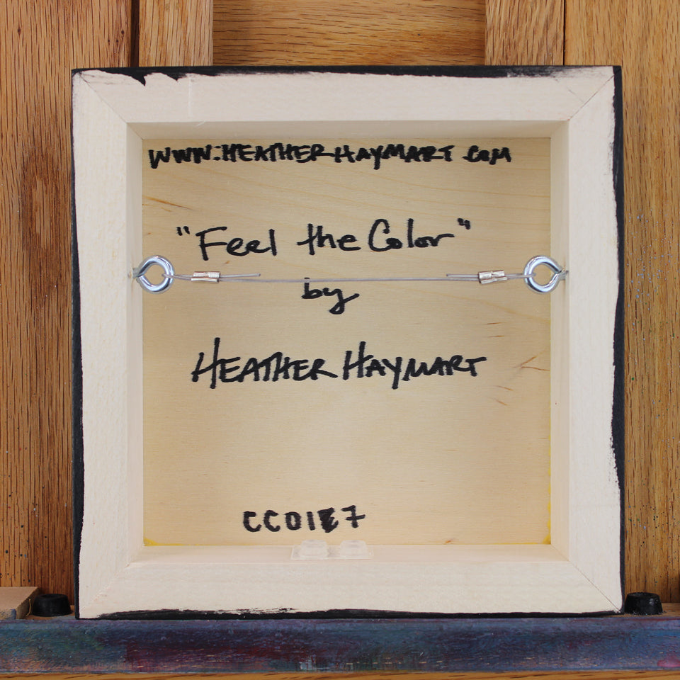 Back view of framed artwork with a wire, signed by Heather Haymart.