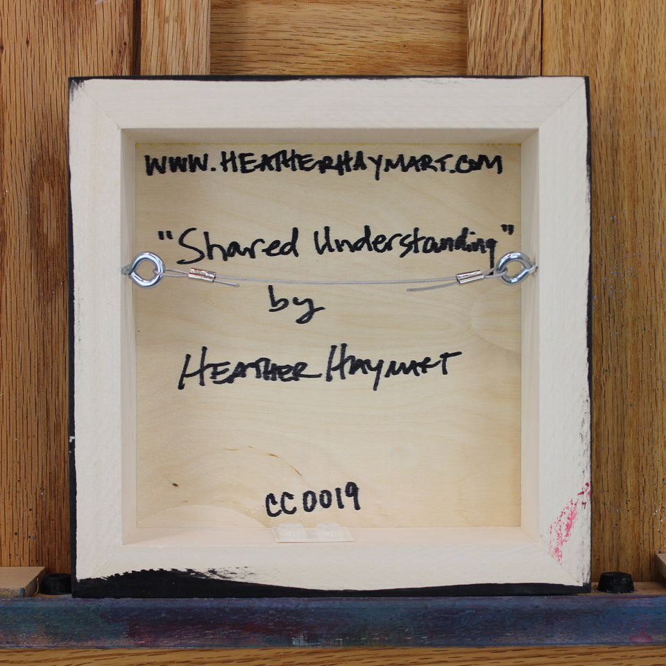 Back view of framed artwork with a wire, signed by Heather Haymart.