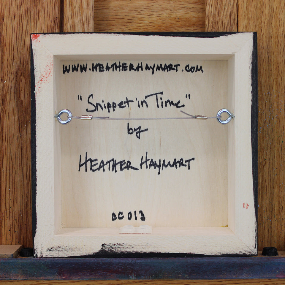 Back view of framed artwork with a wire, signed by Heather Haymart.