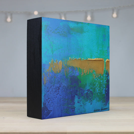 Decorative box with blue and gold abstract design on a light background