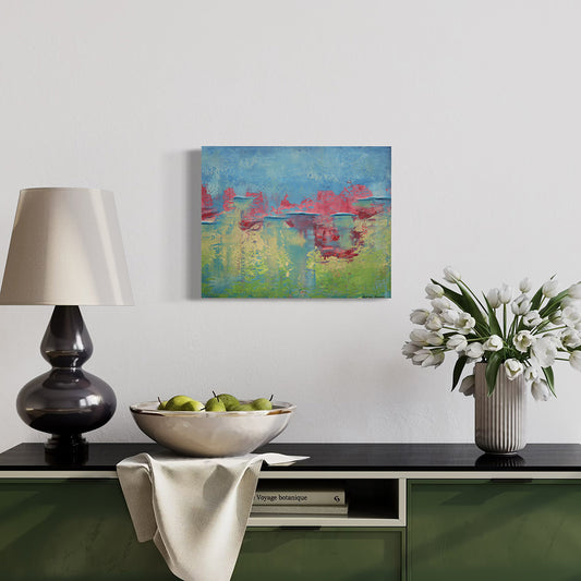 Modern interior with a lamp, bowl of apples, and vase of flowers on a green console table.