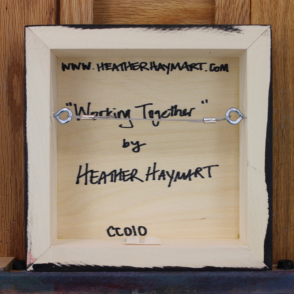 Back view of framed artwork with a wire, signed by Heather Haymart.