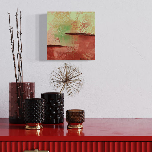 Decorative setup with black textured vases, a dandelion head, and a colorful abstract painting on a white wall.