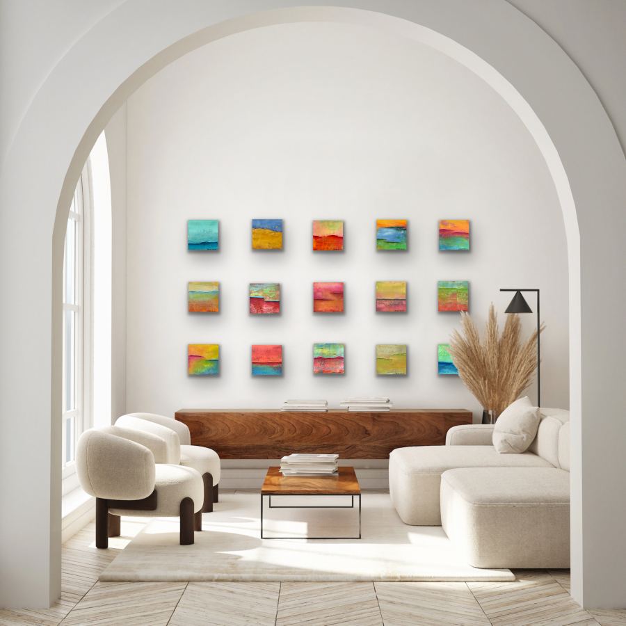 Abstract art grouping of fifteen small paintings on the wall in a living room.