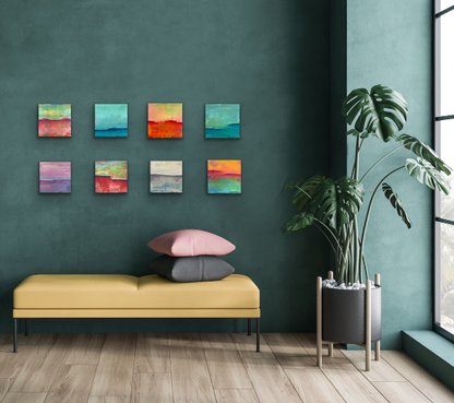 Eight colorful abstract paintings on the wall over sitting couch in the window.