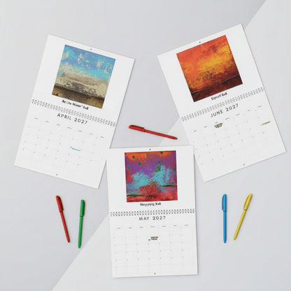 Three printed desk calendars laid out on a light gray surface with small office props. Each calendar page shows a colorful abstract artwork above the month and year, with titles such as 'Be Like Water,' 'Underlying,' and 'Engulf".