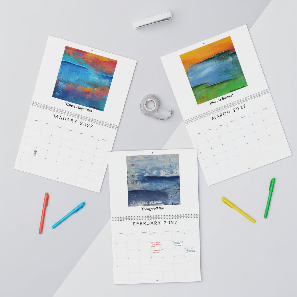 Three printed monthly calendar pages laid out on a light gray surface with art prints for January, March, and February 2027. The pages feature colorful abstract landscape paintings at the top and are styled with tape and pens around them.