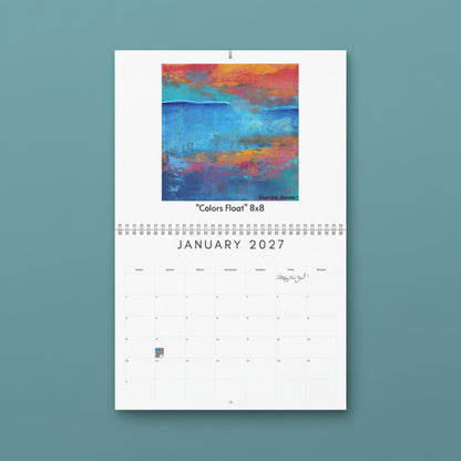 A spiral-bound January 2027 wall calendar page with a colorful abstract painting at the top labeled "Colors Float 8x8" and a white calendar grid below.