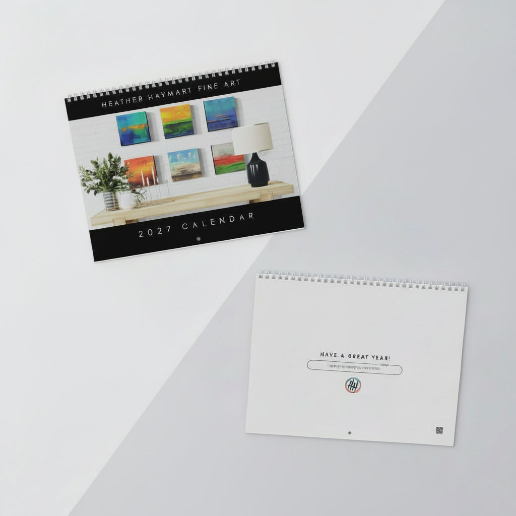 A styled flat-lay of a 2027 spiral-bound calendar from Heather Haymart Fine Art, shown alongside its blank cover page and on a split white and light gray background.