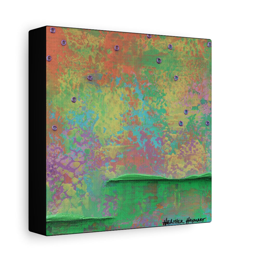 A square abstract canvas wall art print with a textured, multicolored background featuring shades of green, orange, yellow, purple, and blue, with a black side edge and a signature in the bottom right corner.