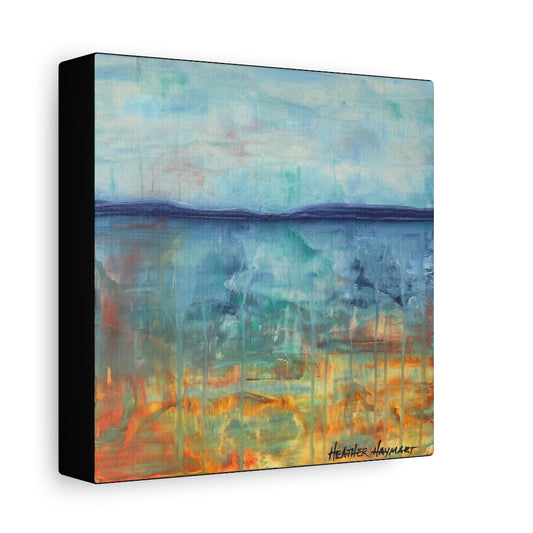 Abstract landscape canvas wall art featuring a blue and teal sky over a reflective body of water with orange and yellow tones near the horizon, shown as a three-quarter perspective view with a black side edge on a white background.