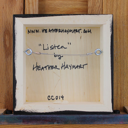Back view of framed artwork with a wire, signed by Heather Haymart.