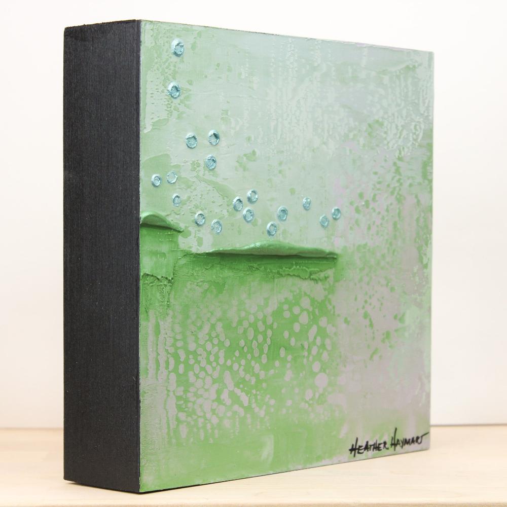 side view of artwork with shades of green, gray and duck egg blue