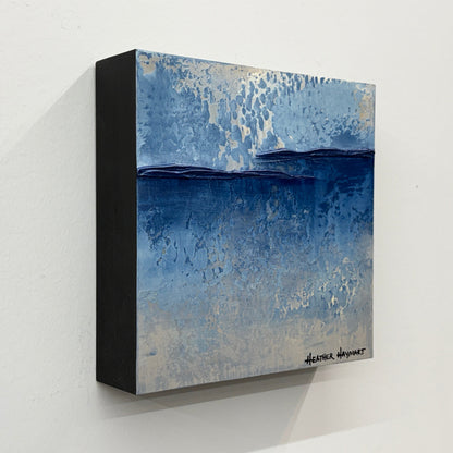 Side view of abstract texture art with blue and gray tones on a white wall