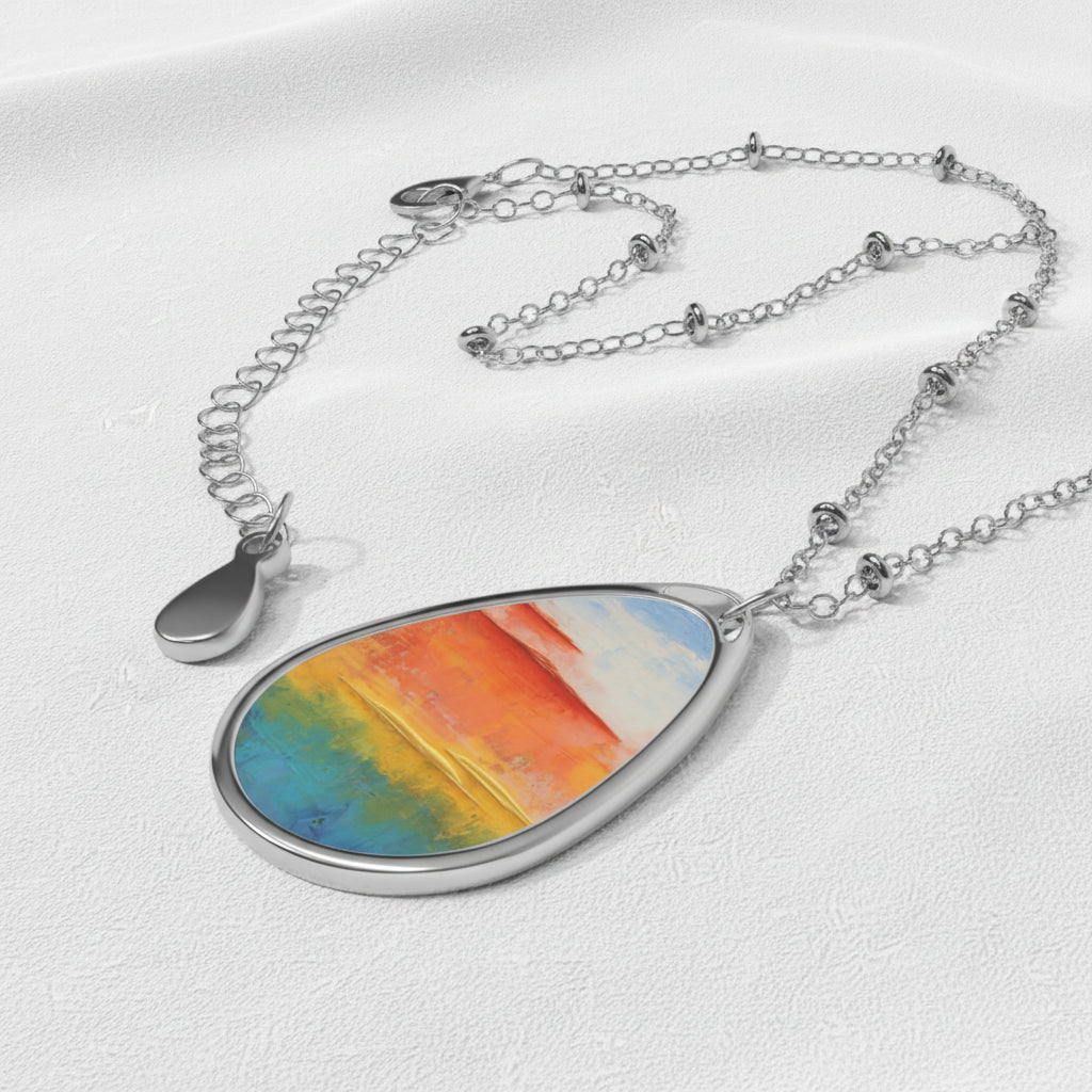 An art necklace with a simple, elegant design featuring a colorful, ellipse-shaped pendant on a silver chain.