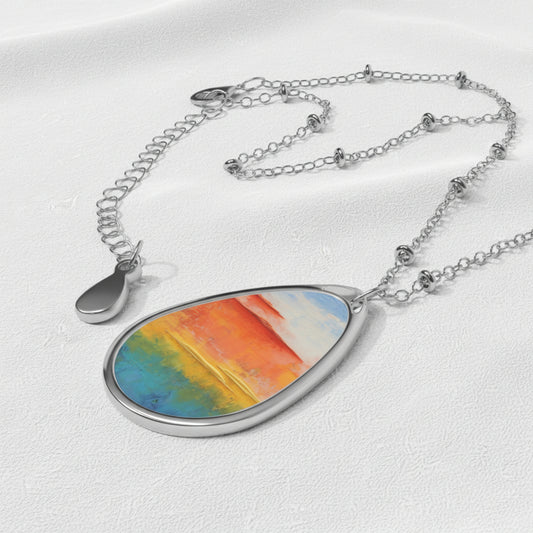 An art necklace with a simple, elegant design featuring a colorful, ellipse-shaped pendant on a silver chain.