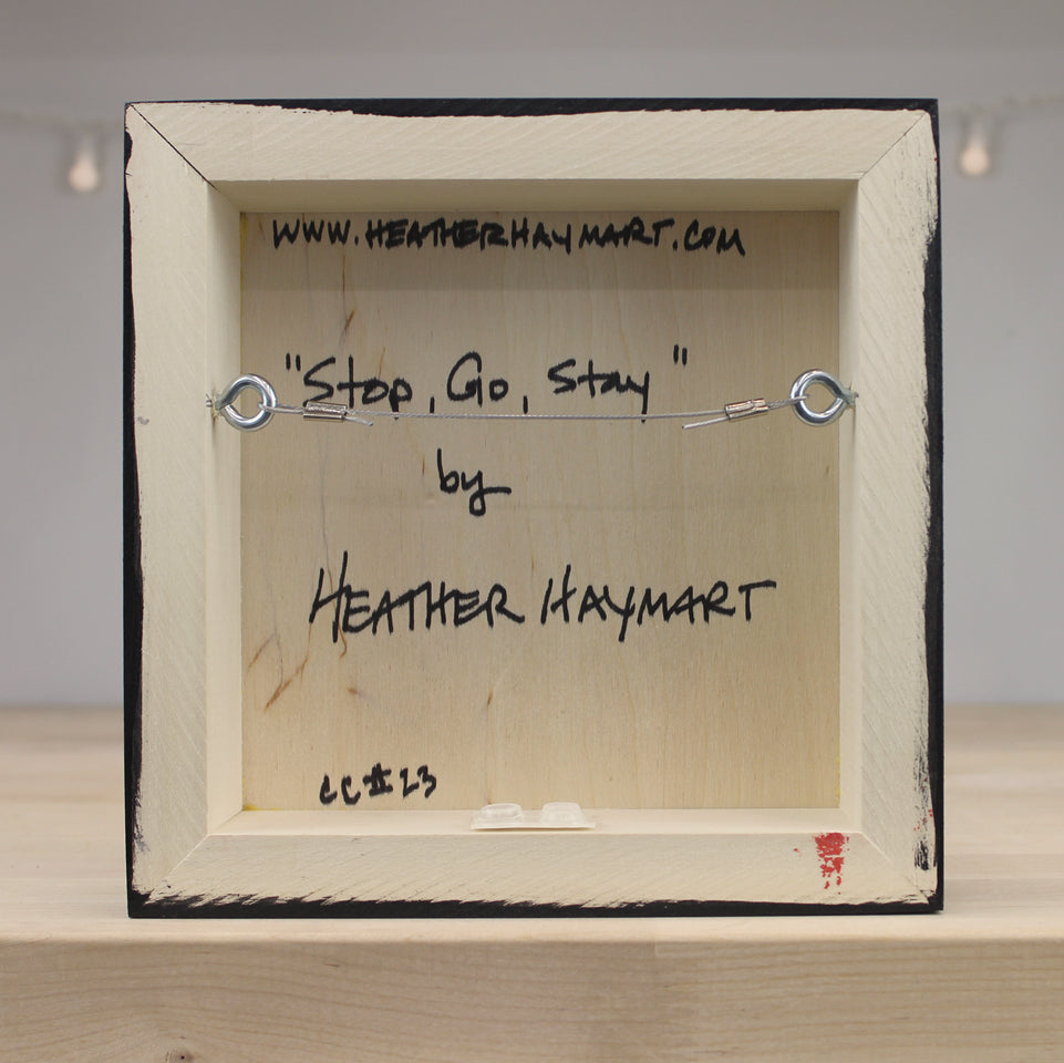 Back of a framed artwork with text and a website URL.