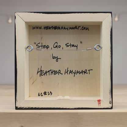 Back of a framed artwork with text and a website URL.