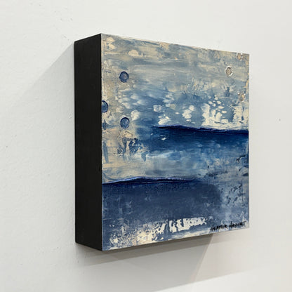 side view of abstract painting with blue and gray tones on a white wall