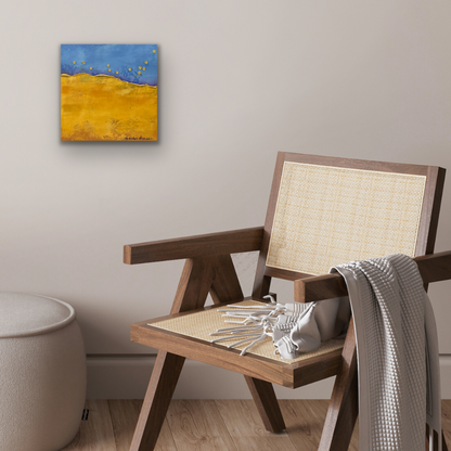 Blue and yellow abstract landscape painting on the wall with a chair