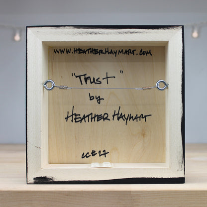 Wooden box with metal wire and text on a light background